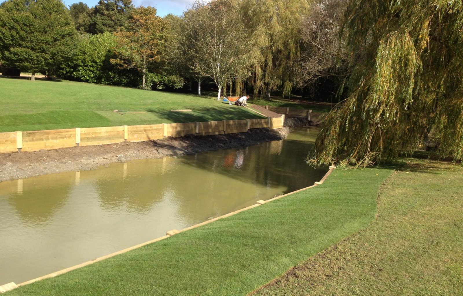 River landscaping with wooden revetments and timber bridge in a country garden in East Anglia. Own professional team carry out all landscaping and construction work. Please browse our website and blog to see more examples of our work.